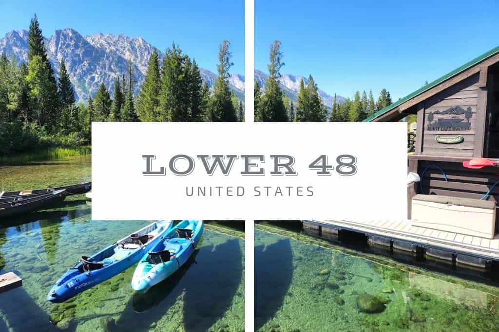 Kayaks floating on clear water next to a wood cabin and surrounded by trees and mountains