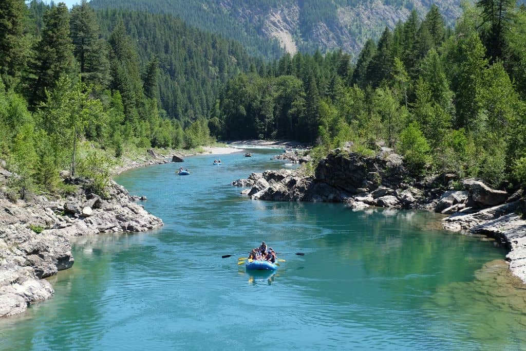 Blue raft floating down a calm channel in the mountains