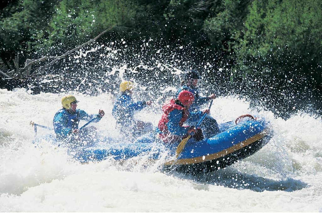 Group of rafters getting splashed in heavy rapids