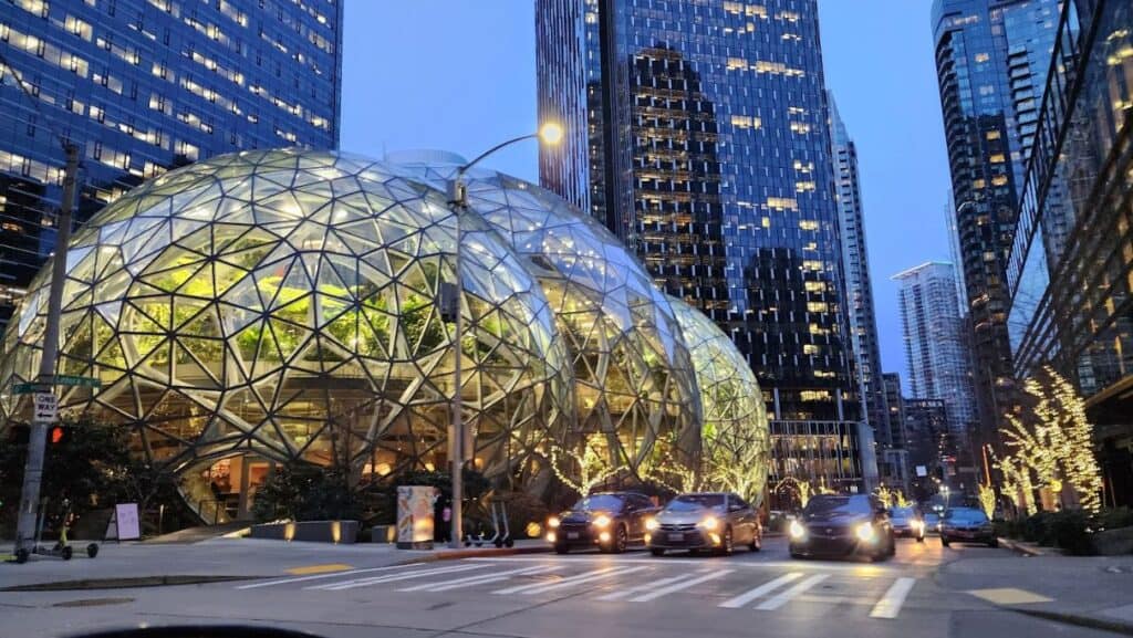 Night view of downtown city with illuminated glass, round buildings and cars