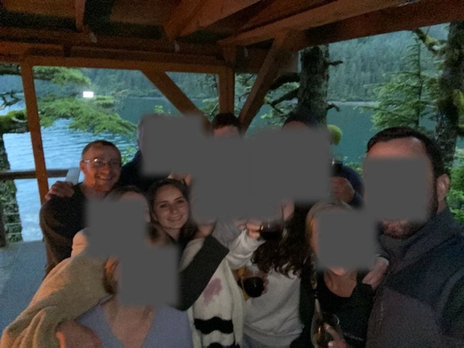 Group of people with most of their faces blurred out on a covered deck on the ocean