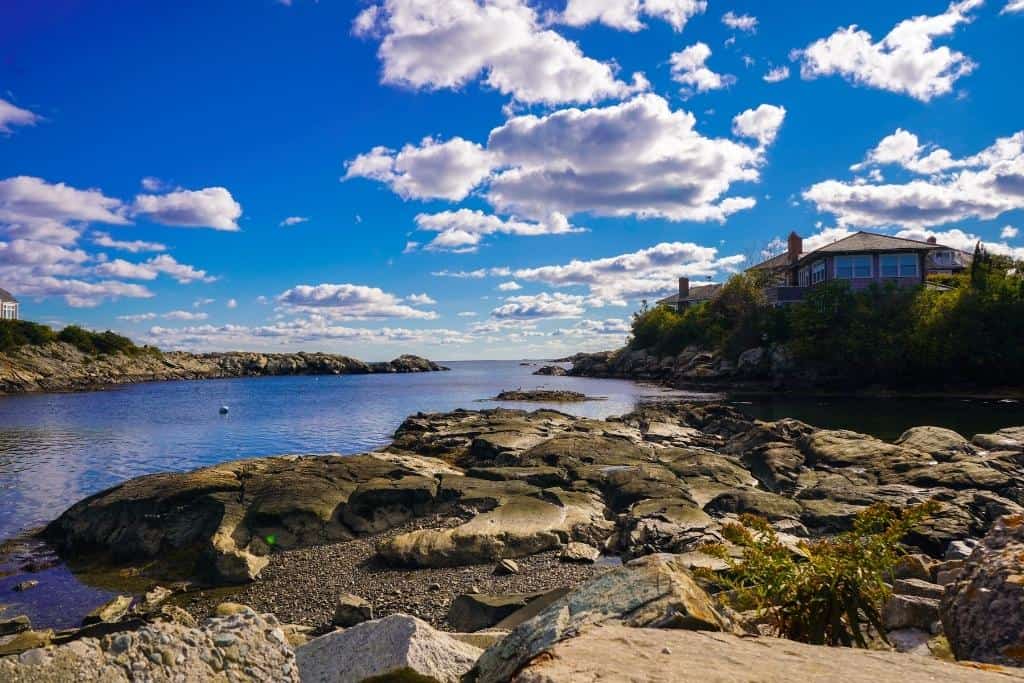 Rocky Rhode Island coastline with a large house overlooking a small inlet