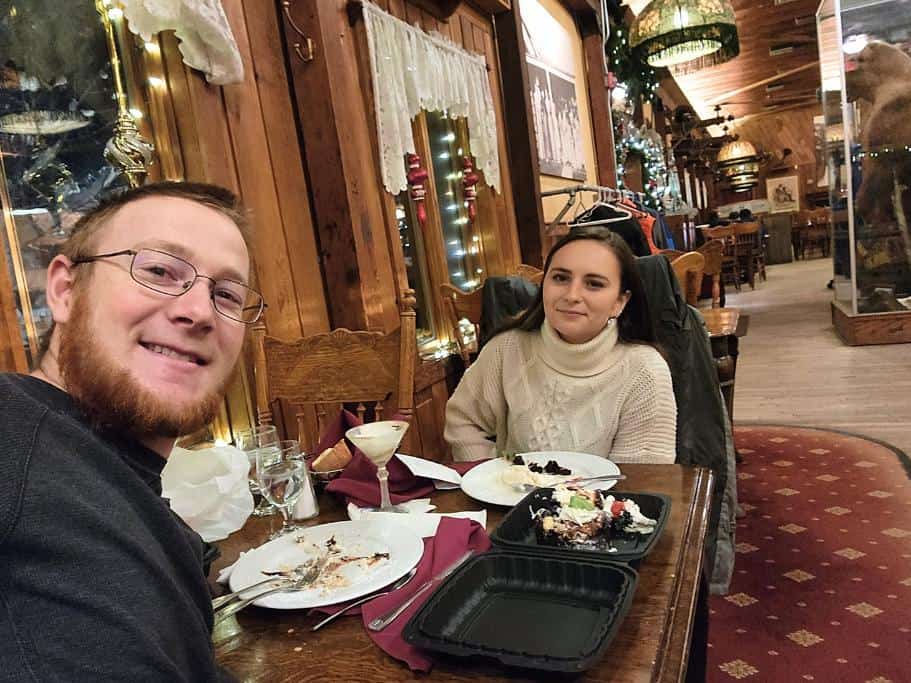 A man and a woman sitting at a restaurant table with a partially carpeted floor
