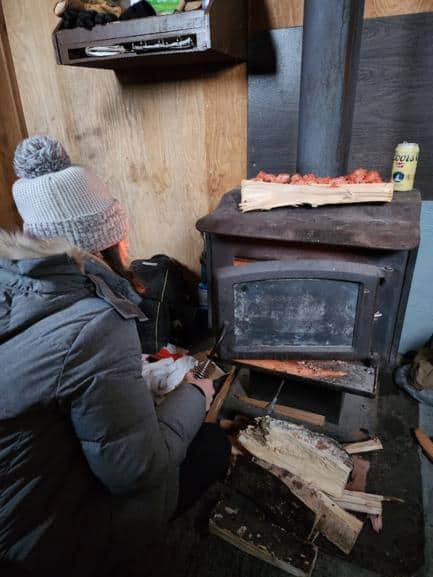 Most Fairbanks ice fishing tours will bring wood to stock the wood stove like the one in this picture