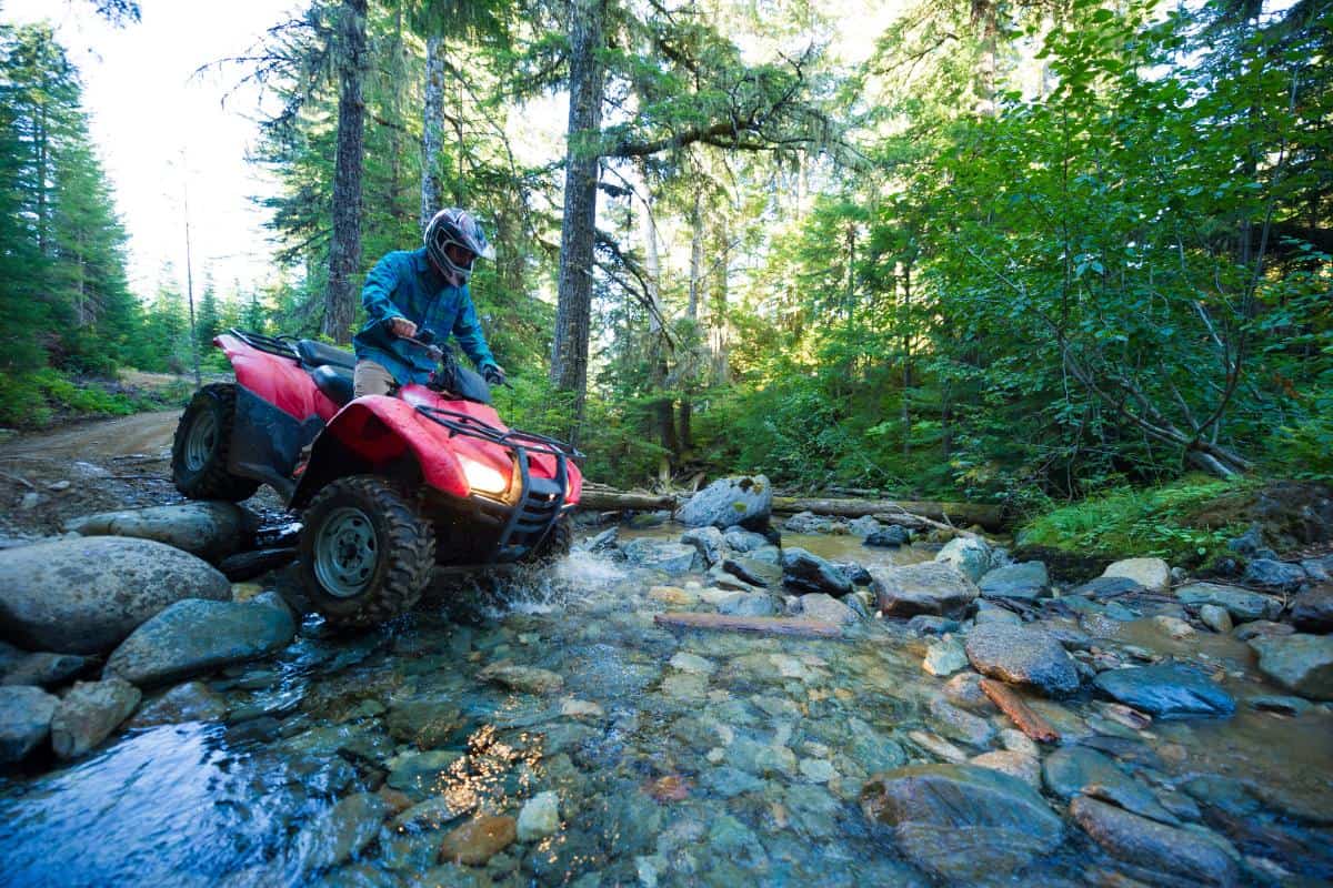 ATV crossing a stream in the woods