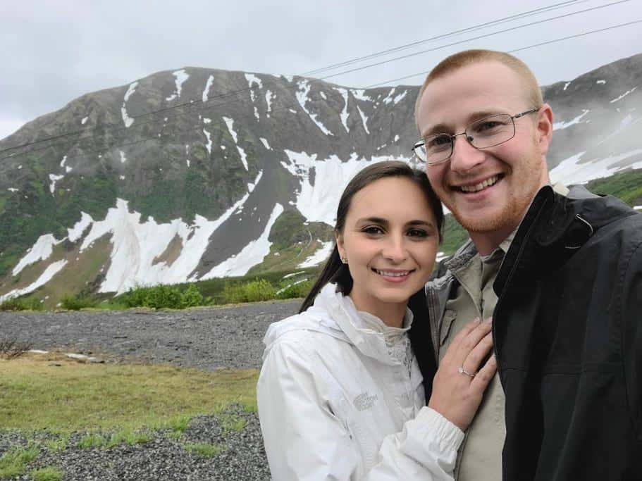 A man and woman standing in the mountains smiling