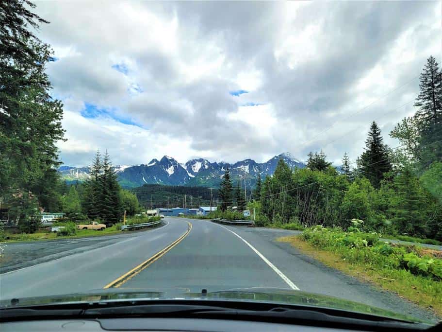 Car windshield with distant mountains and pine trees