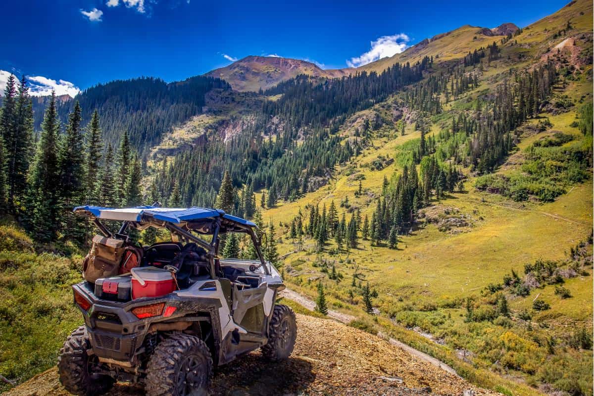 Small ATV on a lookout over tree-covered mountains