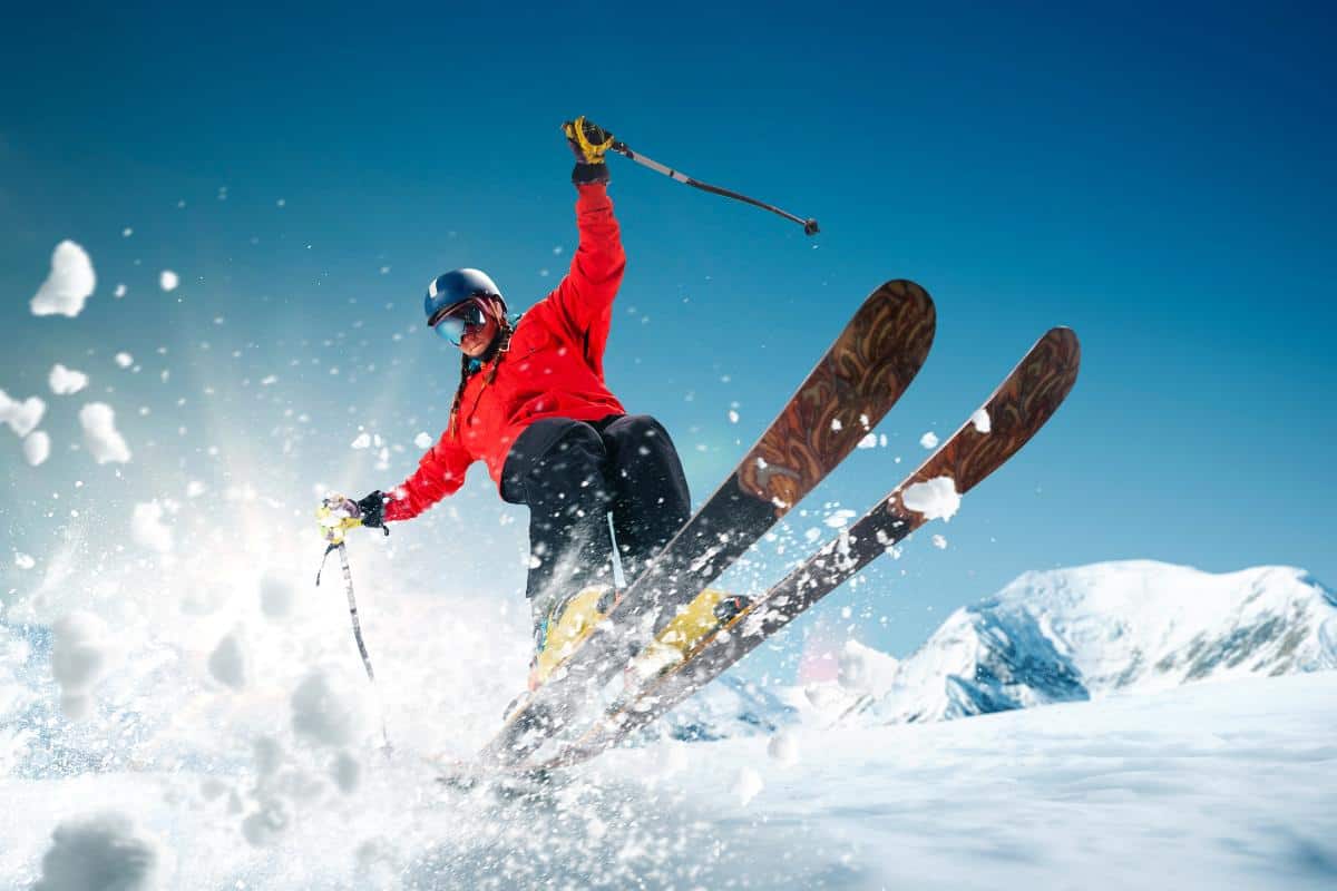 Skier going off a jump in a red jacket