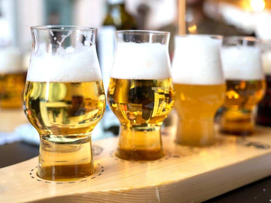 Flight of skinny glasses on a wooden board filled 3/4 full