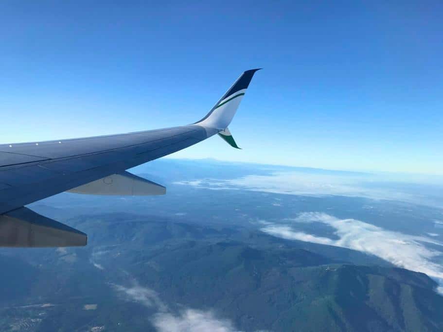 Airplane wing flying over mountains