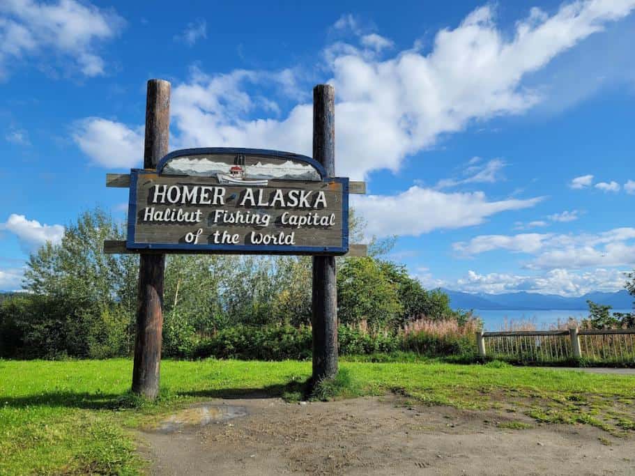 Tall, wooden sign that reads "Homer Alaska" Halibut Fishing Capital of the World" on a sunny day