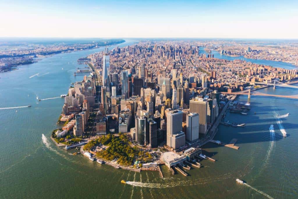 Aerial view of large city surrounded by water and boats on a sunny day