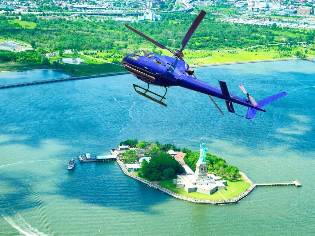 Blue helicopter turning over the Statue of Liberty island
