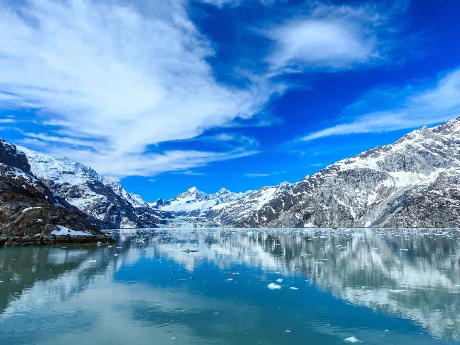 Icy blue bay with a blue sky and snow-covered mountains
