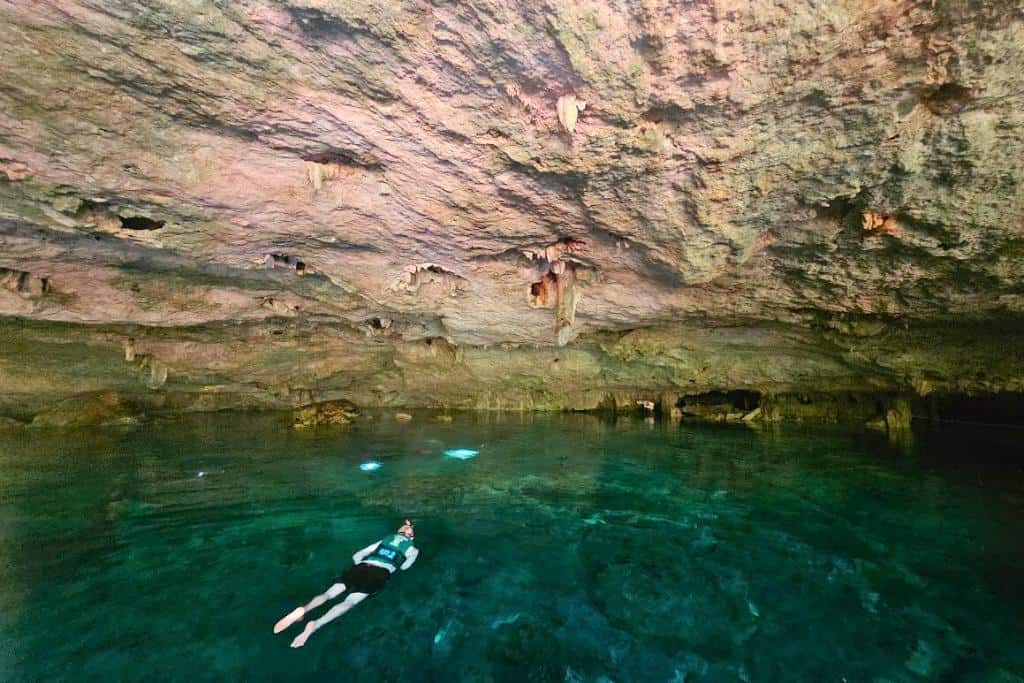 Man swimming in a large cenote in Mexico