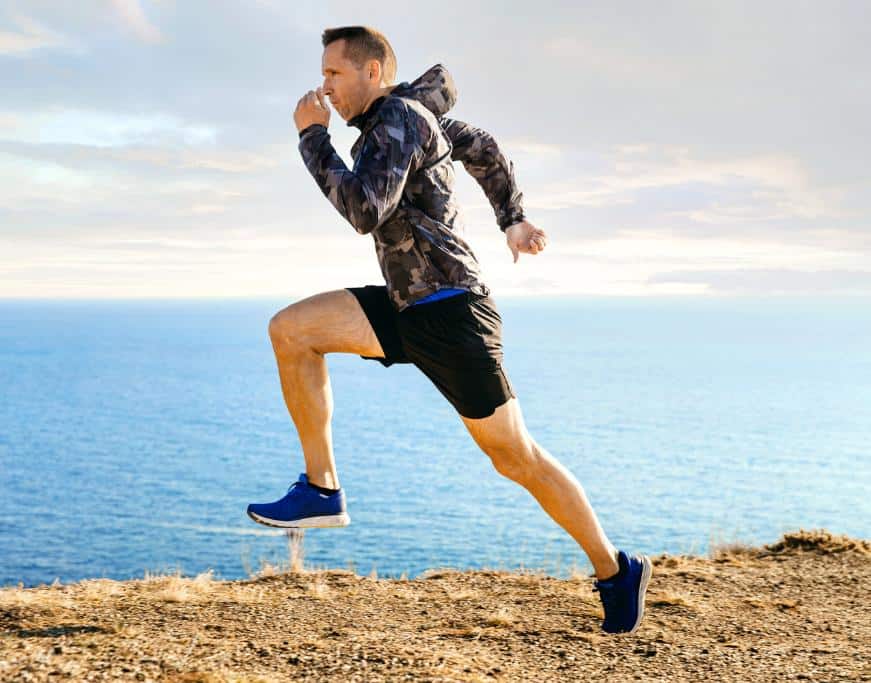 Man in athletic wear running near the coast