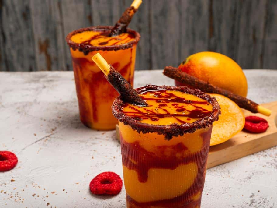 Orange beverage in red, spice-rimmed cups