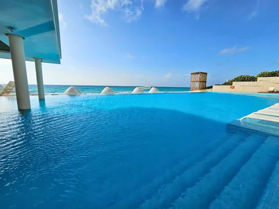 Blue infinity pool with cabanas overlooking the ocean