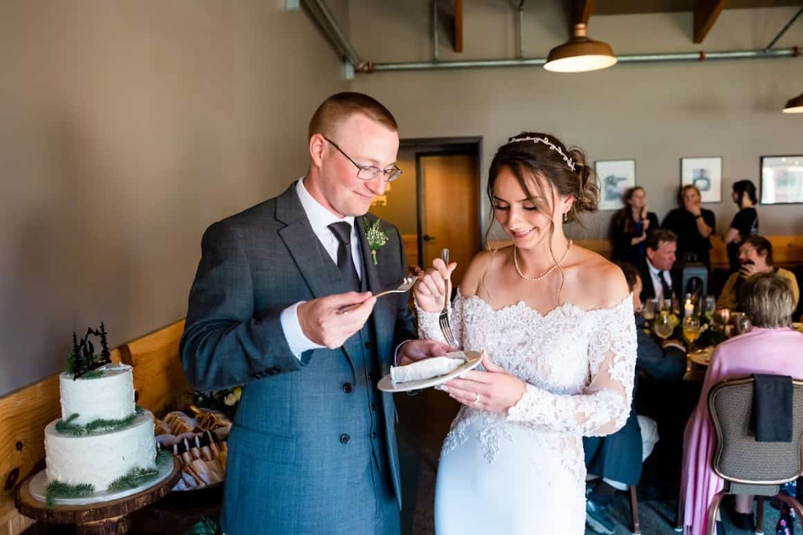 Sean and Emily Concannon eating cake on their wedding day in Seward, Alaska
