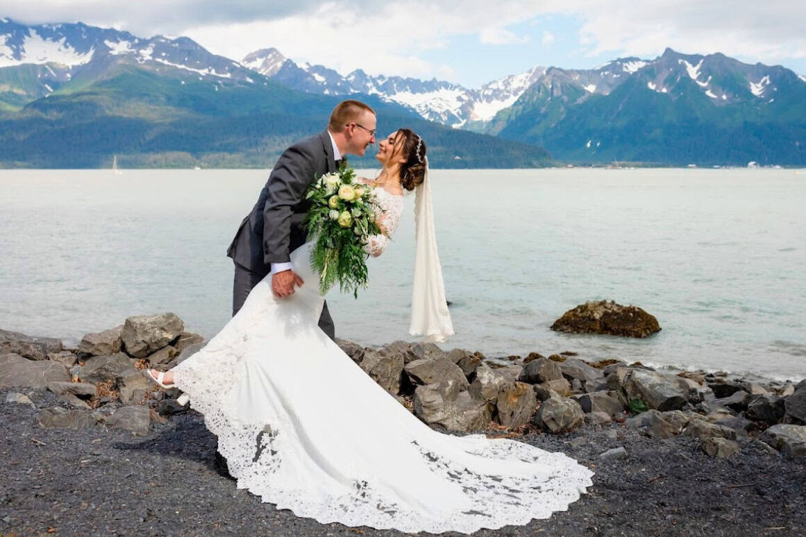 Sean "dipping" Emily Concannon in their wedding attire on Ressurection Bay in Alaska