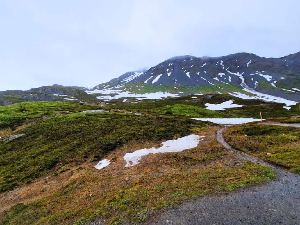 Gravel trail going through the mountains on a rainy day in Alaska