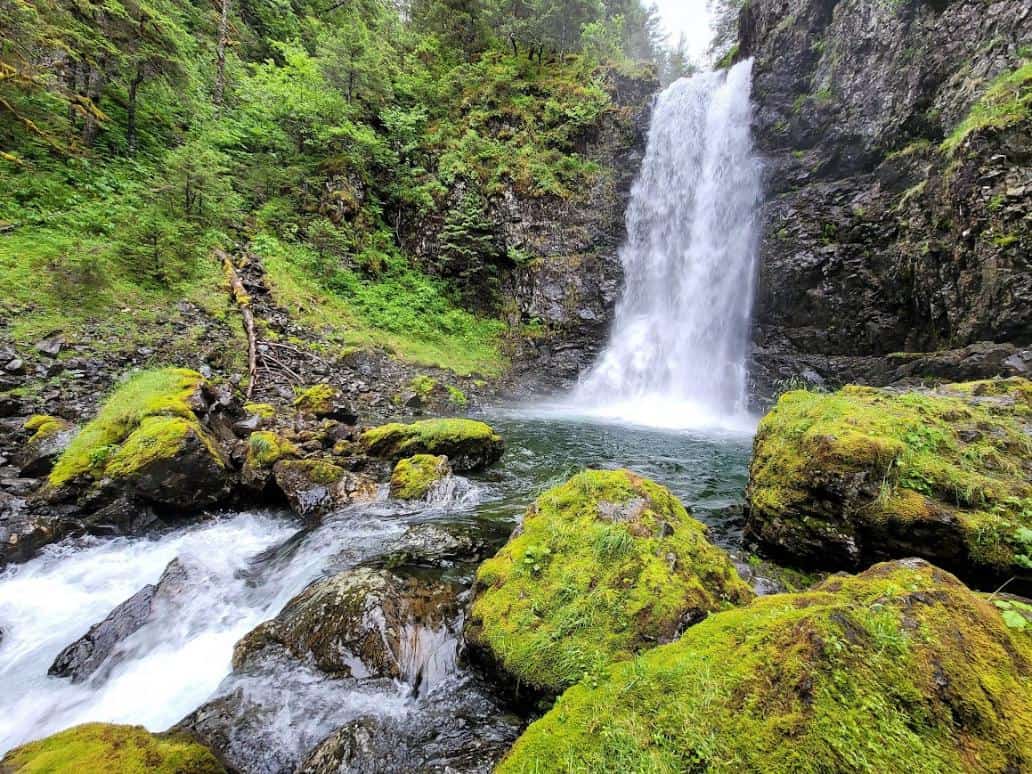 Rushing waterfall surrounded by mossy rocks in Alaska