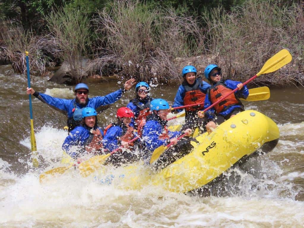 A group of people whitewater rafting on Class III rapids on the Poudre River in Colorado