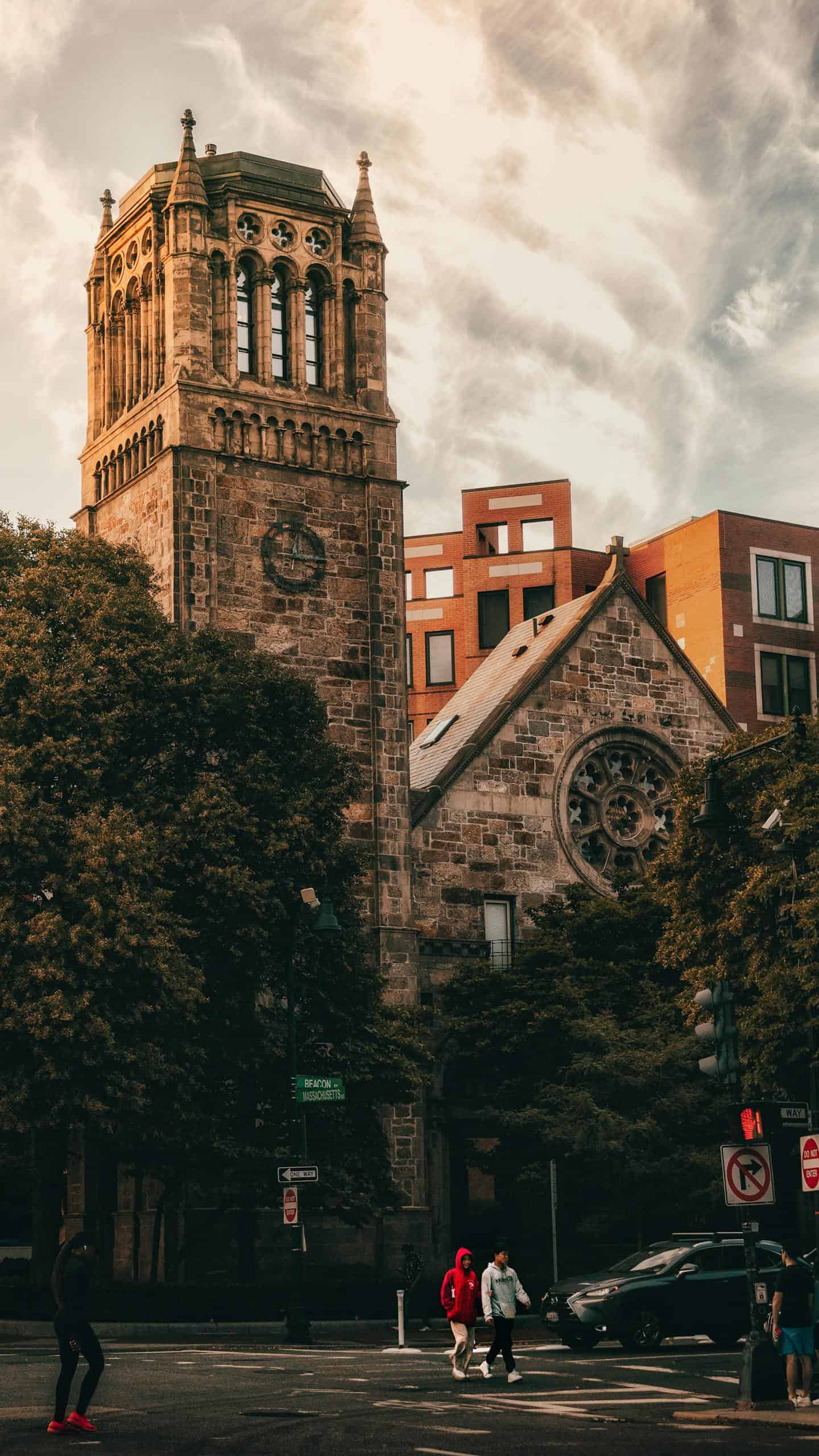 Classic stone church architecture in Boston with people and trees.
