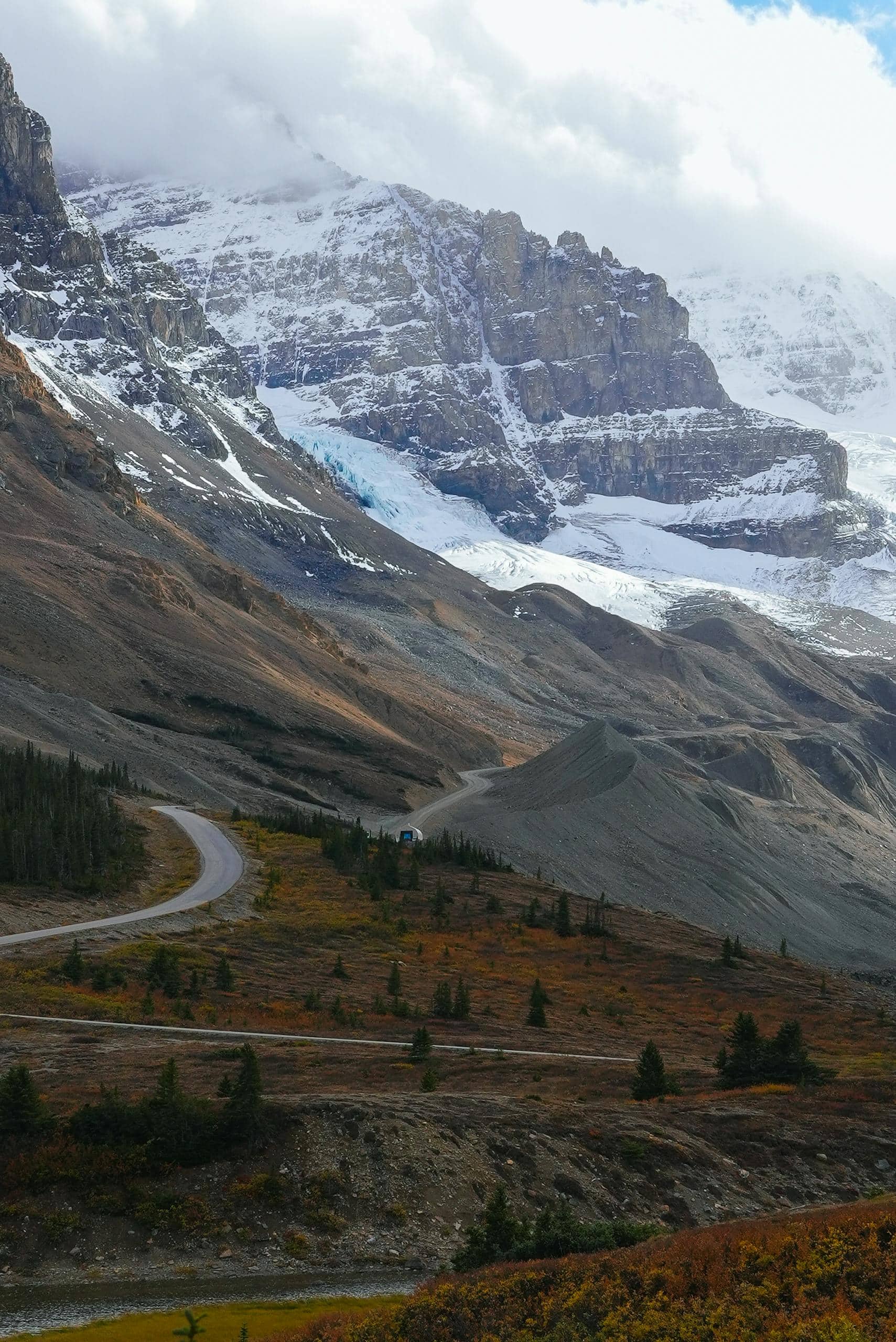 Breathtaking view of snow-capped mountains and winding road in the Canadian Rockies.