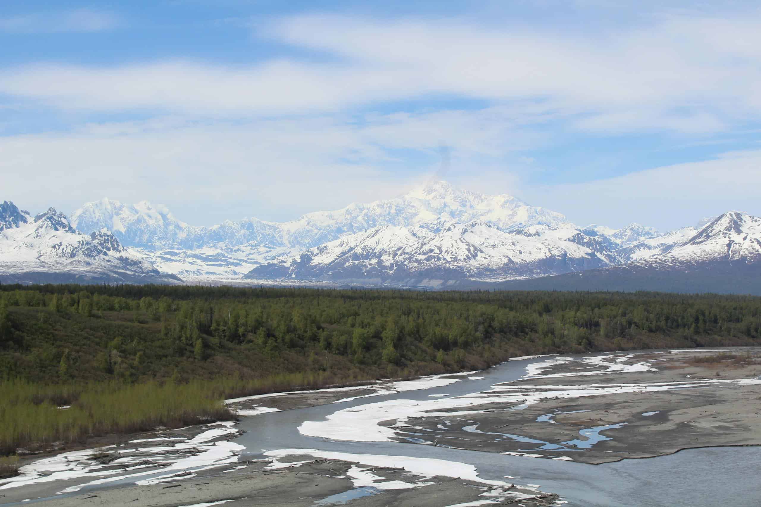 Panoramic view of snow-capped mountains and river in Denali National Park, Alaska.